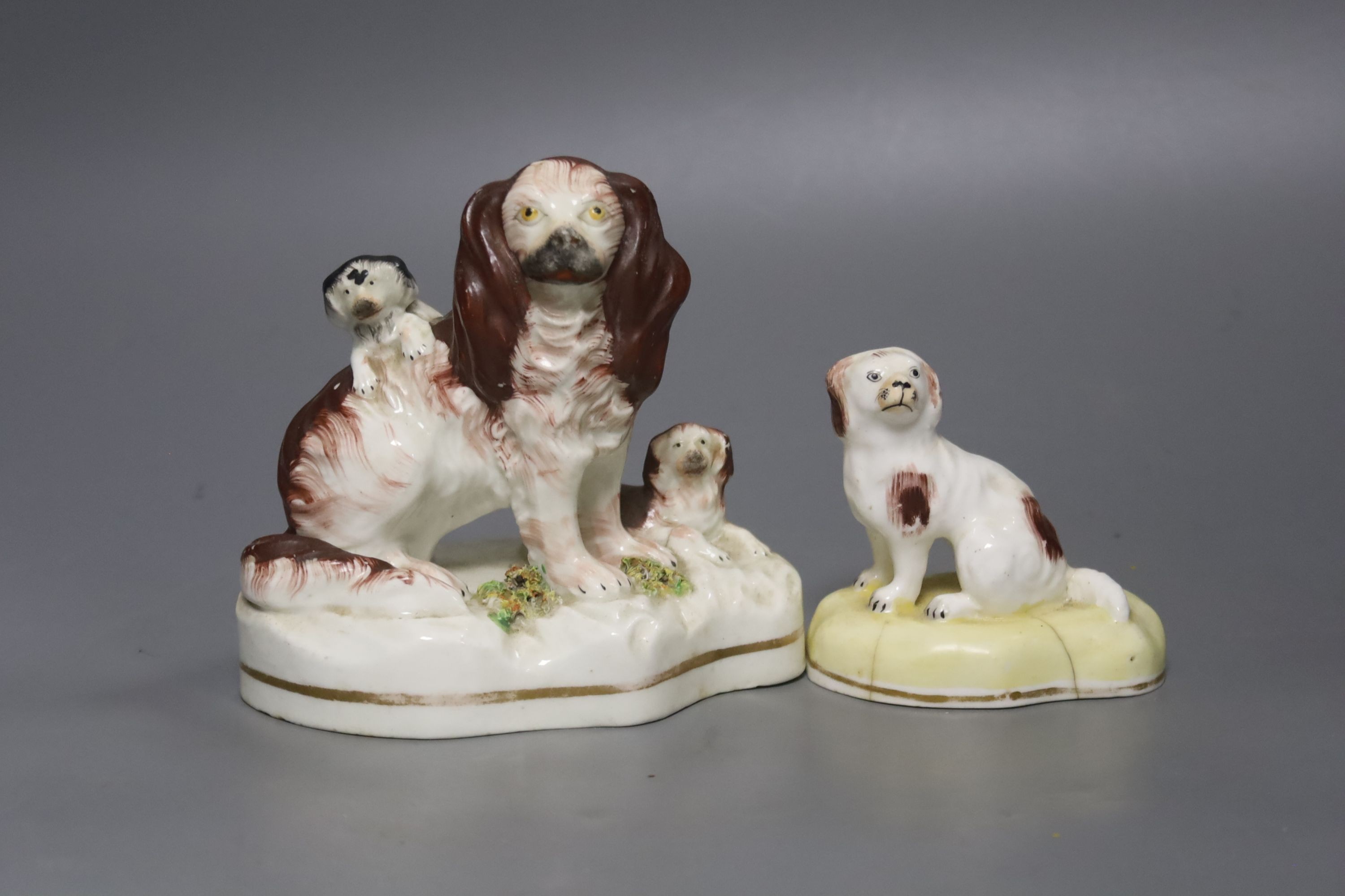 A Victorian Staffordshire spaniels group and a small porcelain dog